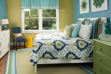 オースティンにある中くらいなトラディショナルスタイルのおしゃれな客用寝室 (マルチカラーの壁、無垢フローリング、暖炉なし、茶色い床) のインテリア