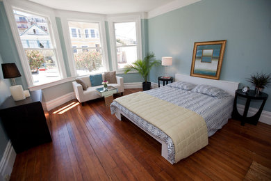 Foto de habitación de invitados tradicional renovada grande sin chimenea con paredes azules y suelo de madera en tonos medios