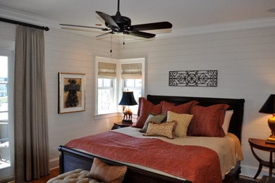 Imagen de dormitorio tradicional de tamaño medio con paredes blancas, suelo de madera en tonos medios y todas las chimeneas