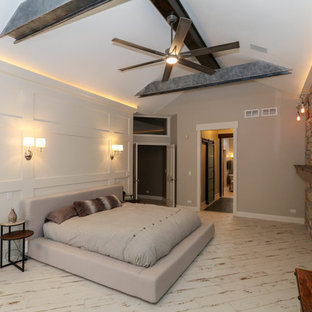 Modelo de dormitorio principal, urbano, grande, con paredes beige, suelo de baldosas de cerámica, chimenea tradicional, marco de chimenea de piedra y suelo beige