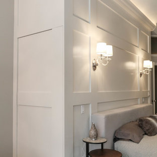 Diseño de dormitorio principal, urbano, grande, con paredes beige, suelo de baldosas de cerámica, chimenea tradicional, marco de chimenea de piedra y suelo beige