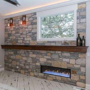 Diseño de dormitorio principal, industrial, grande, con paredes beige, suelo de baldosas de cerámica, chimenea tradicional, marco de chimenea de piedra y suelo beige