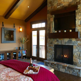 Foto de habitación de invitados tradicional renovada, de tamaño medio, sin chimenea, con paredes beige, suelo de madera oscura, marco de chimenea de piedra y suelo marrón