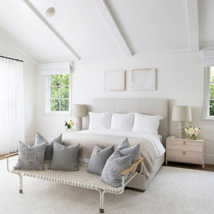 Modelo de habitación de invitados clásica renovada, grande, con paredes beige, suelo de madera en tonos medios y suelo marrón