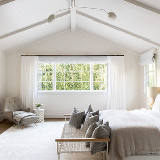 Example of a large minimalist guest light wood floor and beige floor bedroom design in New York with beige walls