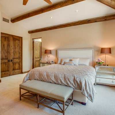 Huge tuscan master carpeted bedroom photo in Los Angeles with beige walls and no fireplace