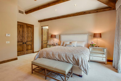 Ejemplo de dormitorio principal mediterráneo extra grande sin chimenea con paredes beige y moqueta