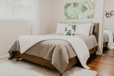 Modelo de dormitorio principal retro de tamaño medio sin chimenea con paredes beige, suelo de madera oscura y suelo marrón