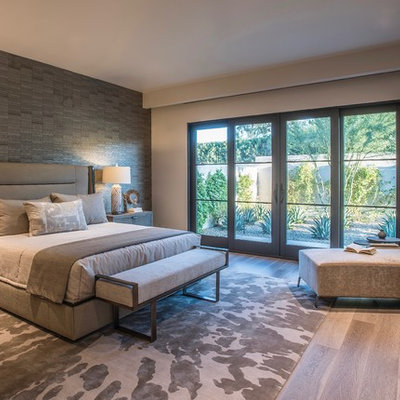Example of a large trendy master medium tone wood floor and beige floor bedroom design in Phoenix with beige walls
