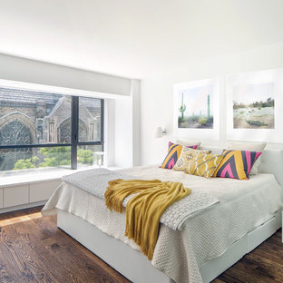 Diseño de dormitorio principal, actual, con suelo de madera en tonos medios y paredes blancas