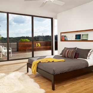 Idee per una camera da letto minimalista con pareti bianche, parquet chiaro, pavimento giallo e letto davanti alla finestra