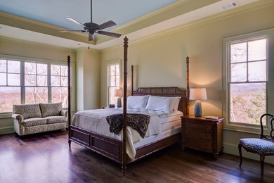 Imagen de dormitorio principal tradicional de tamaño medio sin chimenea con paredes verdes y suelo de madera oscura