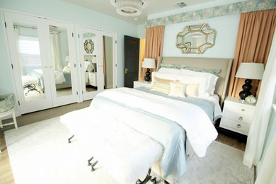 Imagen de dormitorio principal clásico de tamaño medio sin chimenea con paredes azules y suelo de madera oscura