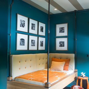 Modelo de habitación de invitados industrial, de tamaño medio, sin chimenea, con paredes azules, suelo de madera oscura y suelo marrón