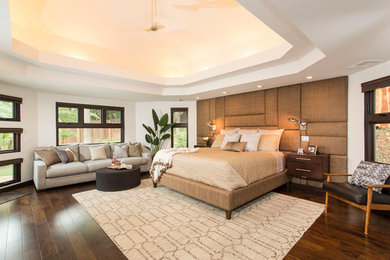 Example of a large trendy master dark wood floor and brown floor bedroom design in San Diego with white walls and no fireplace