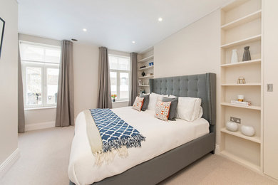 Large modern bedroom in Kent with beige walls.