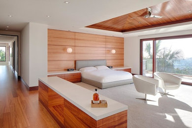 Exemple d'une chambre parentale tendance de taille moyenne avec un mur blanc, un sol en bois brun et un sol marron.