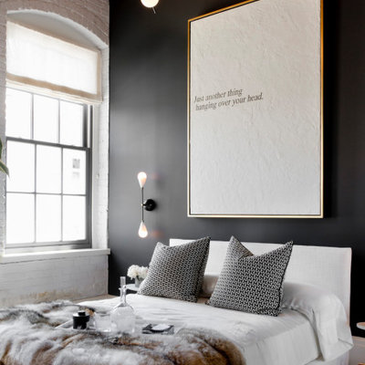 Example of a mid-sized urban medium tone wood floor, brown floor, wood ceiling and brick wall bedroom design in San Francisco with black walls
