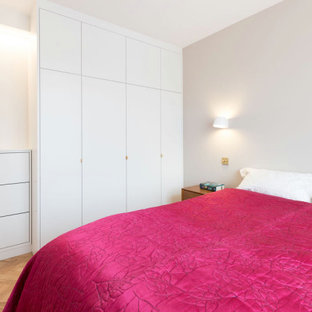Diseño de dormitorio principal, contemporáneo, pequeño, sin chimenea, con paredes beige, suelo de madera clara y suelo marrón