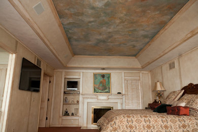 Ejemplo de dormitorio principal de tamaño medio con paredes beige, todas las chimeneas y marco de chimenea de yeso