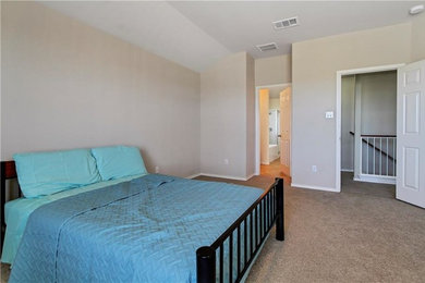 オースティンにある中くらいなトラディショナルスタイルのおしゃれな主寝室 (ベージュの壁、カーペット敷き、ベージュの床) のインテリア