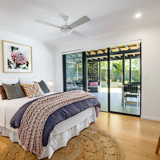 Contemporary bedroom in Sunshine Coast with white walls, medium hardwood floors and brown floor.