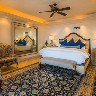 Modelo de dormitorio principal, tradicional renovado, grande, con paredes amarillas y suelo de travertino