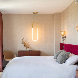 Cette photo montre une grand chambre parentale tendance avec un mur beige, un sol en bois foncé, un sol marron et du papier peint.