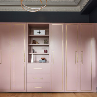 Diseño de dormitorio principal, grande, con paredes azules, suelo de madera en tonos medios y suelo marrón