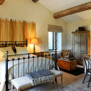 Ejemplo de habitación de invitados de estilo de casa de campo, de tamaño medio, con paredes multicolor, suelo de piedra caliza, chimenea tradicional y suelo multicolor