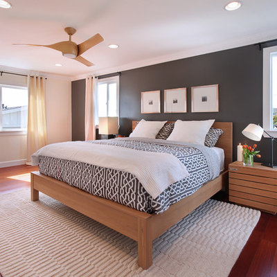 Example of a transitional medium tone wood floor bedroom design in Orange County with black walls and no fireplace