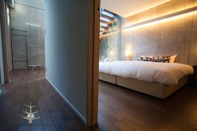Foto de dormitorio principal contemporáneo de tamaño medio con paredes grises y suelo de madera oscura