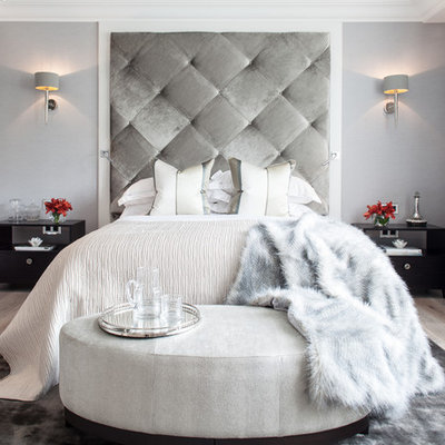 Example of a trendy master light wood floor bedroom design in London with gray walls and no fireplace