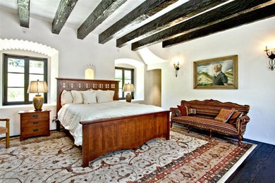 他の地域にある広いラスティックスタイルのおしゃれな主寝室 (白い壁、濃色無垢フローリング、暖炉なし、茶色い床) のレイアウト