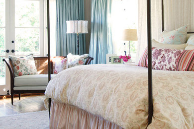 オースティンにある広いコンテンポラリースタイルのおしゃれな主寝室 (ピンクの壁、無垢フローリング、暖炉なし) のレイアウト