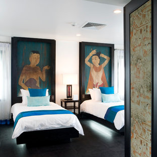 Imagen de habitación de invitados tropical, de tamaño medio, con paredes multicolor, suelo de madera oscura y suelo negro