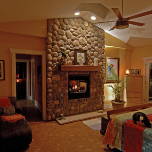 Foto de dormitorio principal, ecléctico, grande, con marco de chimenea de piedra, paredes beige, suelo de corcho, chimenea de doble cara y suelo beige