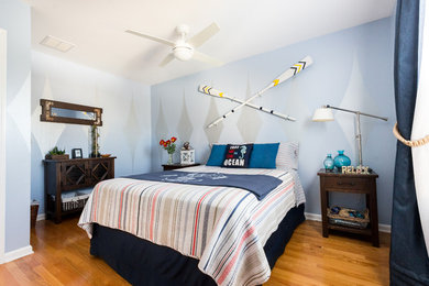 Imagen de habitación de invitados marinera de tamaño medio con paredes azules y suelo de madera clara