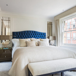 This is an example of a medium sized classic master bedroom in London with beige walls, carpet and beige floors.