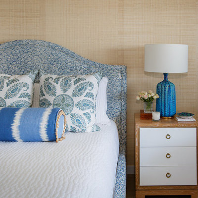 Example of a large beach style master medium tone wood floor bedroom design in Jacksonville with beige walls