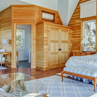 Imagen de habitación de invitados rural, pequeña, sin chimenea, con paredes marrones, suelo de contrachapado y suelo marrón