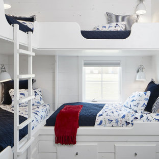 Diseño de dormitorio tipo loft, costero, de tamaño medio, con paredes blancas, suelo vinílico y suelo marrón