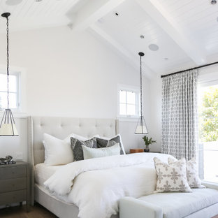 Großes Klassisches Hauptschlafzimmer mit weißer Wandfarbe, braunem Holzboden, Kamin und beigem Boden in Orange County