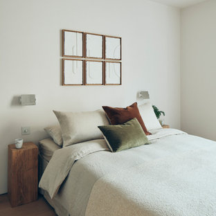 Foto de dormitorio principal, actual, de tamaño medio, con paredes blancas, suelo de madera clara y suelo beige