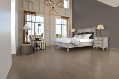 Imagen de dormitorio principal clásico renovado grande sin chimenea con paredes grises, suelo de madera en tonos medios y suelo marrón