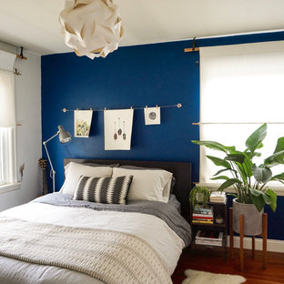 Ejemplo de dormitorio principal, retro, de tamaño medio, sin chimenea, con paredes azules y suelo de madera clara