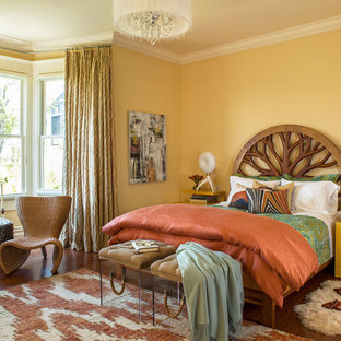Diseño de dormitorio principal, bohemio, de tamaño medio, sin chimenea, con paredes amarillas y suelo de madera en tonos medios