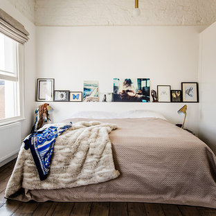 Esempio di una camera da letto boho chic con pareti bianche e pavimento in legno massello medio