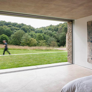 Imagen de dormitorio moderno con suelo de cemento