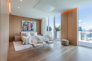 This is an example of a large contemporary master and grey and brown bedroom in Miami with brown walls, light hardwood flooring, beige floors and no fireplace.